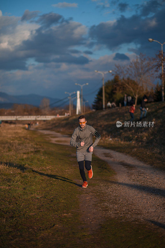 一个在河边锻炼/跑步的年轻人